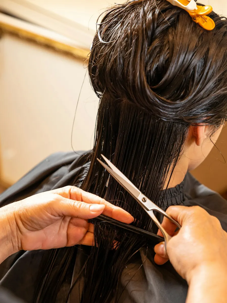 A stylist cutting a woman's hair